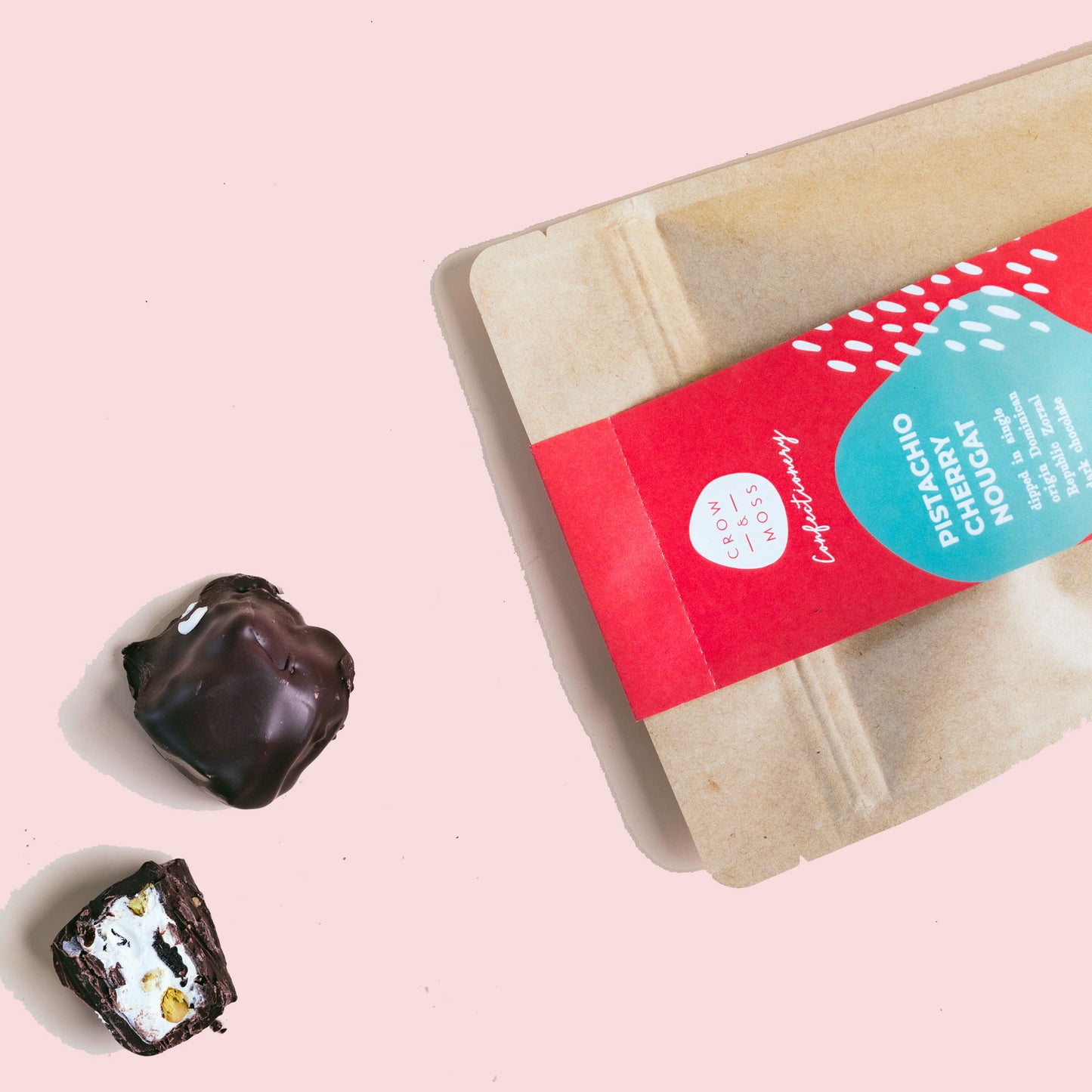 Image of the front of a bag of chocolate covered nougat with two nougat in the foreground.