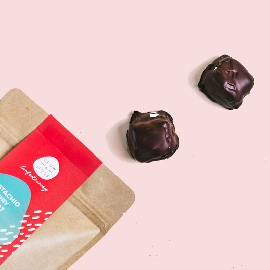 Image of the front of a bag of chocolate covered nougat with two nougat in the foreground.